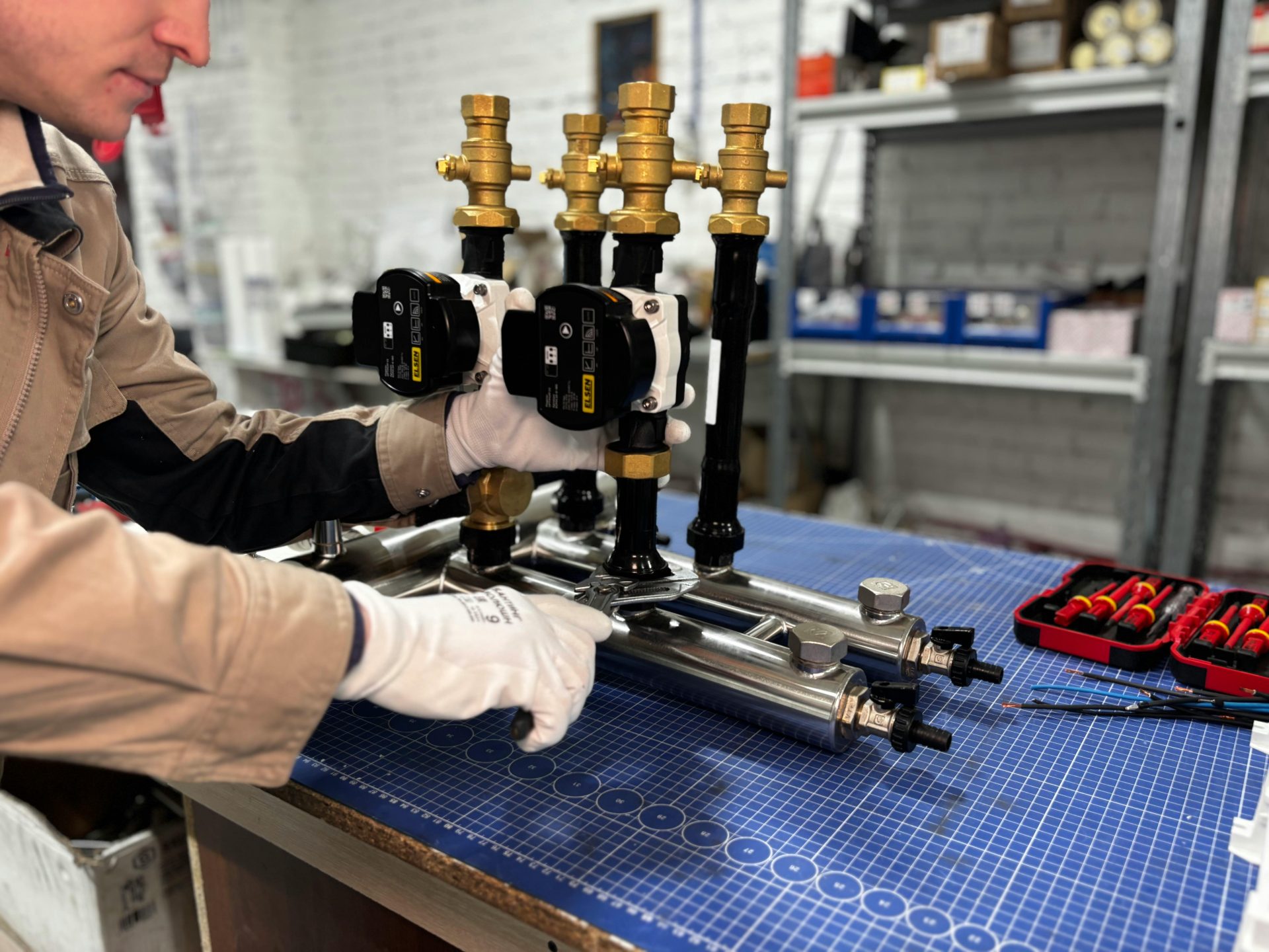 Ein Ingenieur montiert ein Rohrleitungssystem für industrielle Heizungsanlagen, bestehend aus Ventilen und Steuereinheiten.